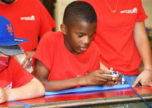 5th grade student maneuvers his SeaPerch underwater ROV (remotely operated vehicle).